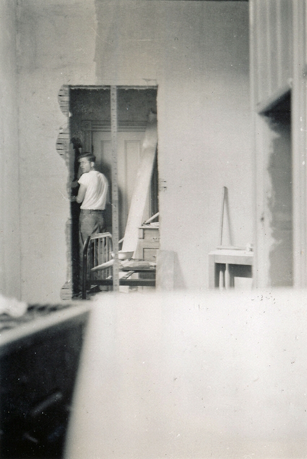 1947-07 1 Pete stripping 5 coats of wallpaper off bedroom wall - I'm standing in kitchen ell, of living room.jpg