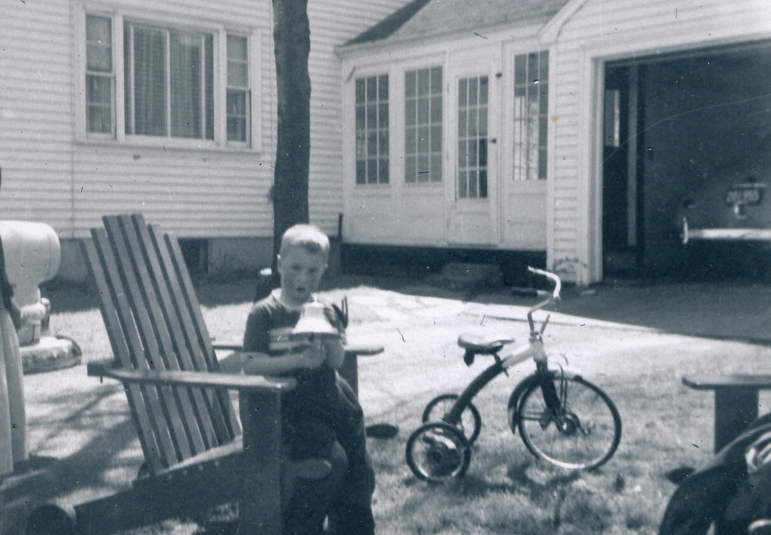 1955-05-01~ 3 Dan with new bell, tricycle, and Mom's original green coupe in garage (HBD Dad & Dan).jpg