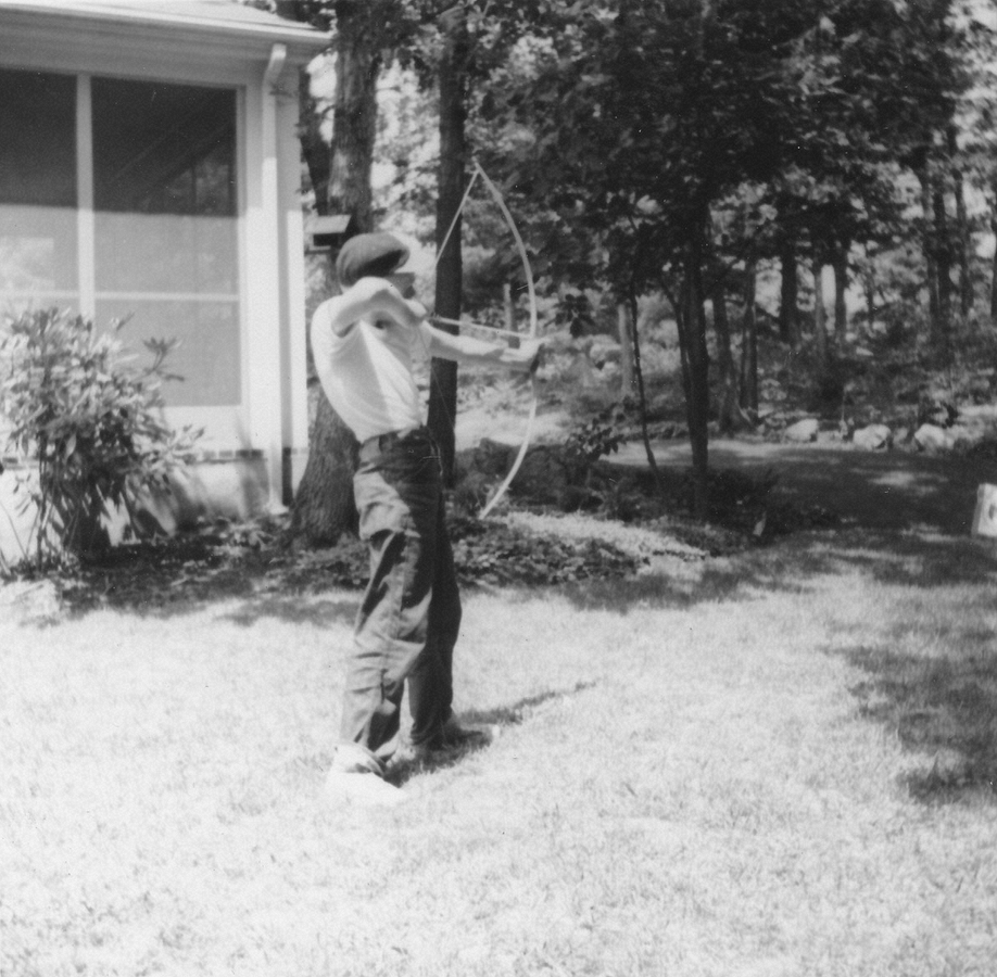 1961-08-01~ 2 Pete Jr practicing archery in back yard, 26 Driftwood Ln, Weston MA.jpg